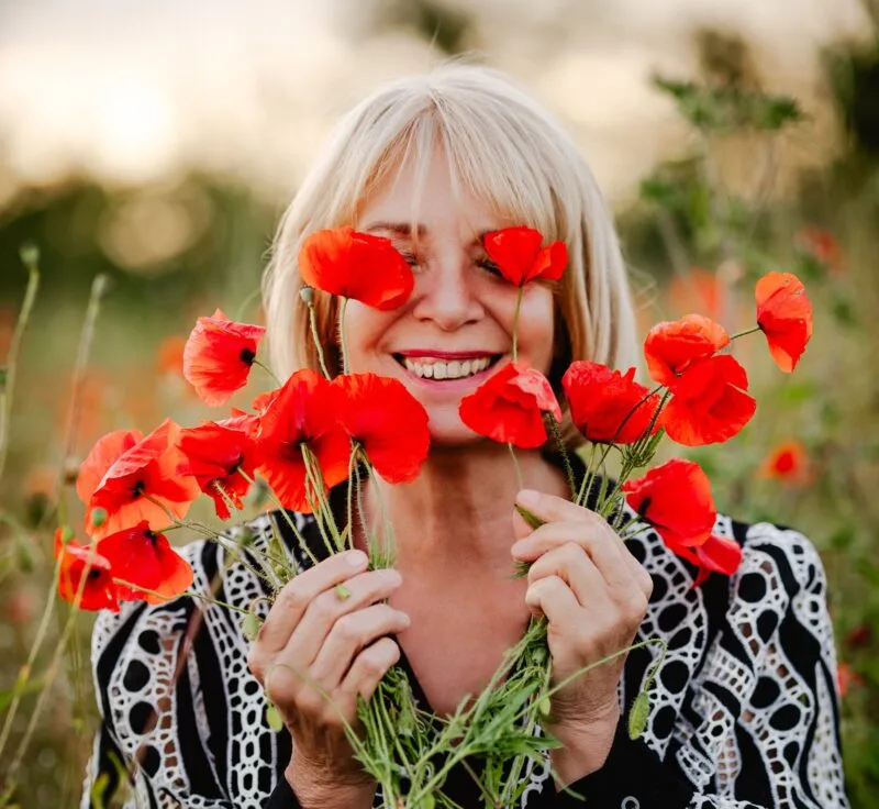 Claudine Vergaert tenant un bouquet de coquelicots devant les yeux