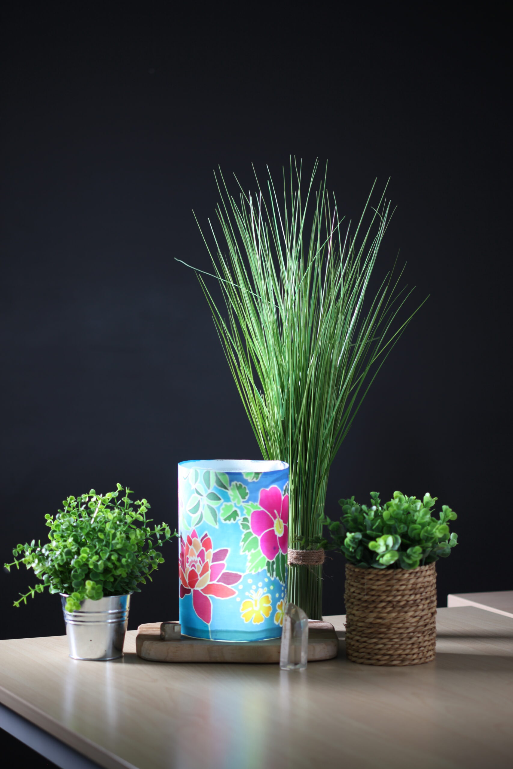 lampe de chevet réalisée en peinture sur soie et présentée entourée de plante sur une table